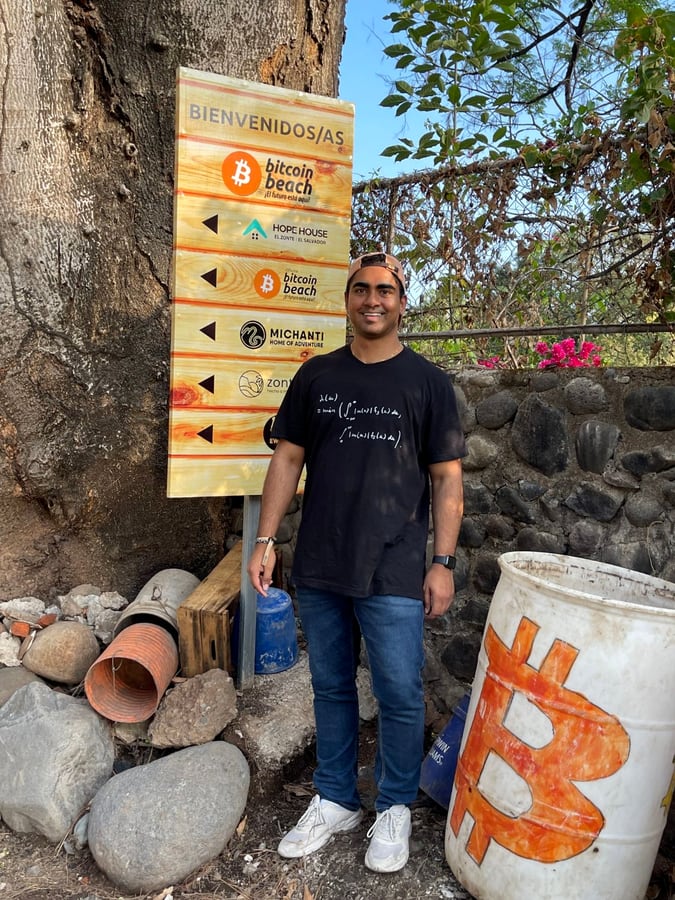 Arvin Bhangu beside a Bitcoin Beach sign in El Zonte, El Salvador.